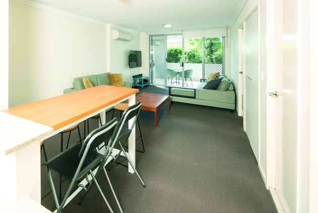 Open-plan living and dining — naturally lit, air-conditioned, set up for daily routine.